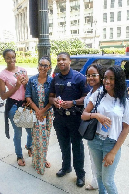 People pose with police officer.