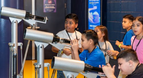 Students looking through telescopes.